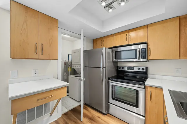 a kitchen with stainless steel appliances a stove microwave and refrigerator