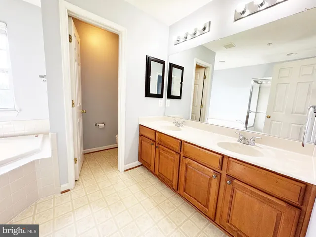 an empty room with windows and ceiling fan