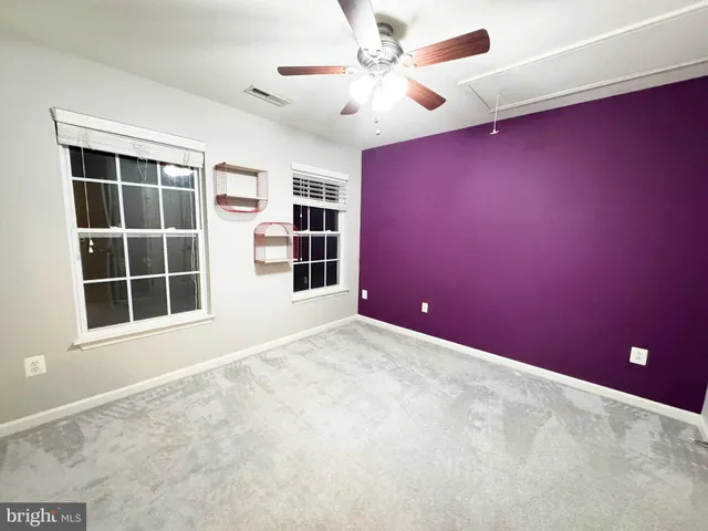 en empty room with windows and fan