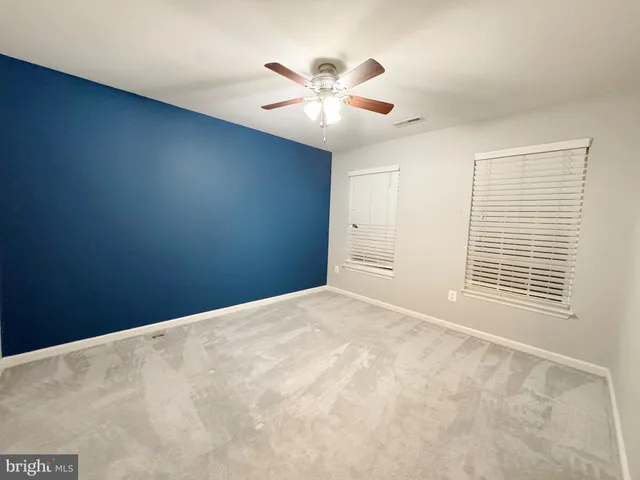 an empty room with a ceiling fan and a window