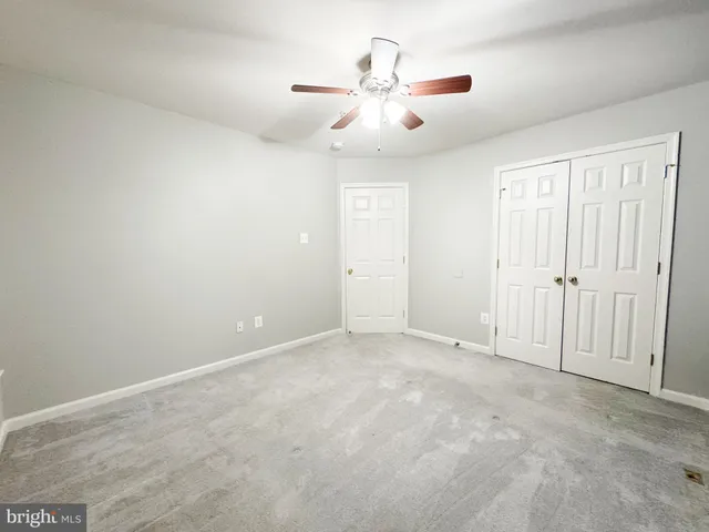 an empty room with chandelier fan