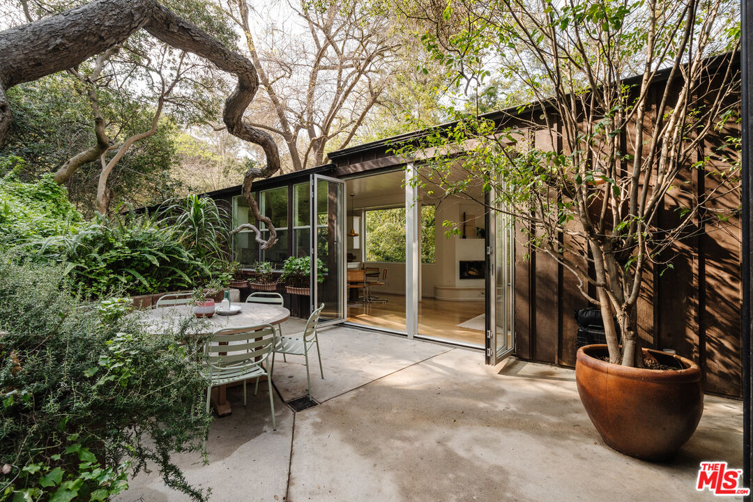 2355 Hermits Glen Los Angeles, CA 90046 - Photo 3 of 45 a view of a backyard with table and chairs and potted plants