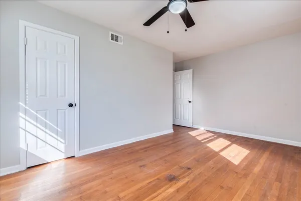 a view of an empty room with wooden floor
