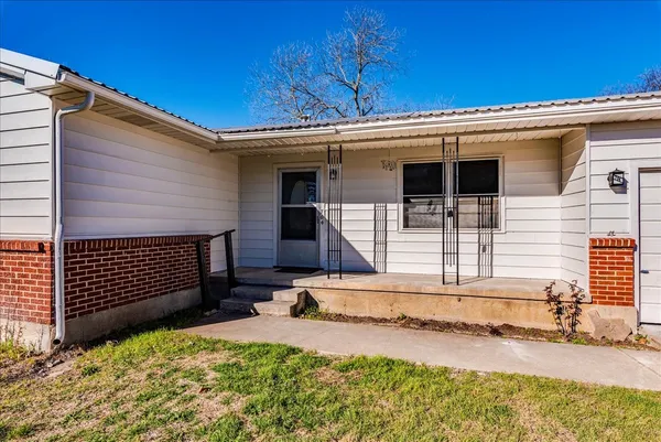 a view of a house with a yard and wooden fence
