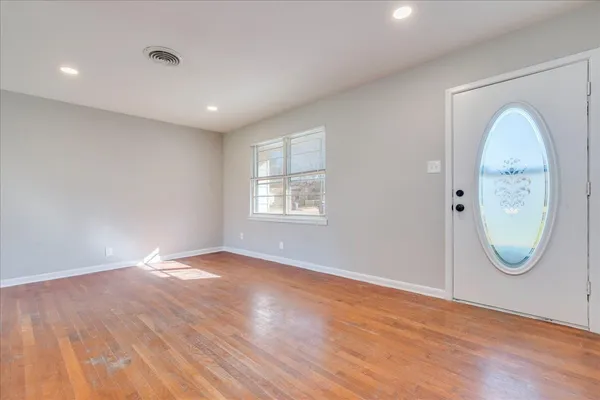 an empty room with window and mirror