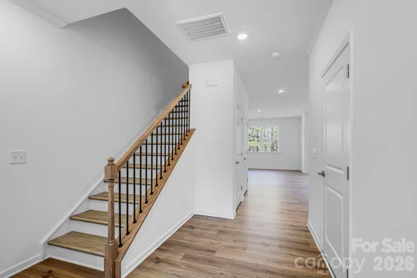 a view of a hallway with wooden floor and staircase