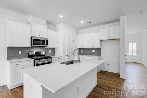 a kitchen with stainless steel appliances a stove a sink a microwave and cabinets