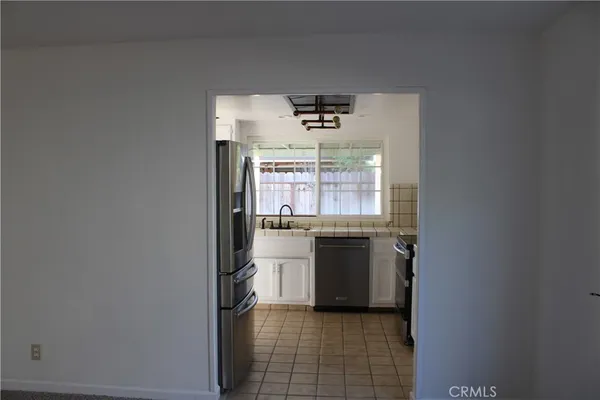 a kitchen with a refrigerator and white cabinets