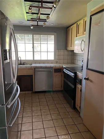 a kitchen with a sink stainless steel appliances and cabinets