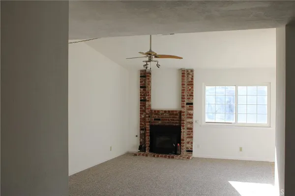 an empty room with fireplace and windows