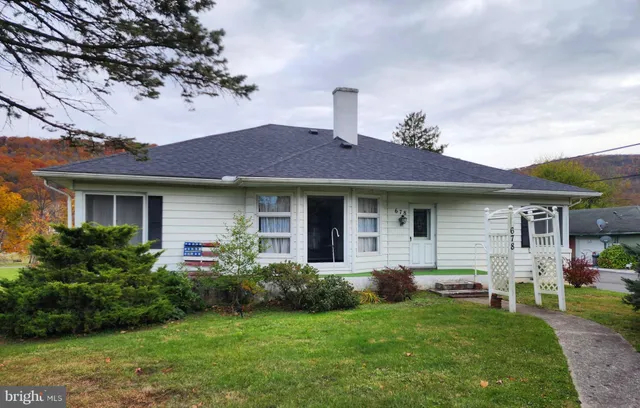 a front view of a house with a garden and plants