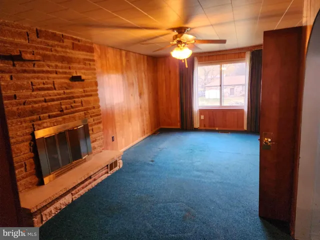 an empty room with closet chandelier fan and windows