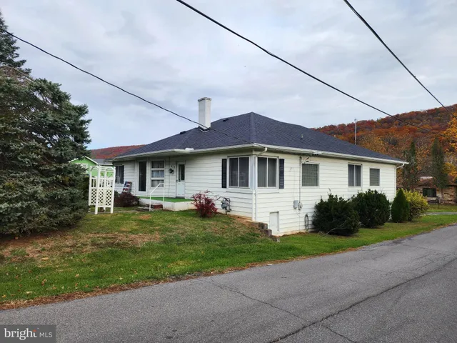 a front view of a house with a garden and yard