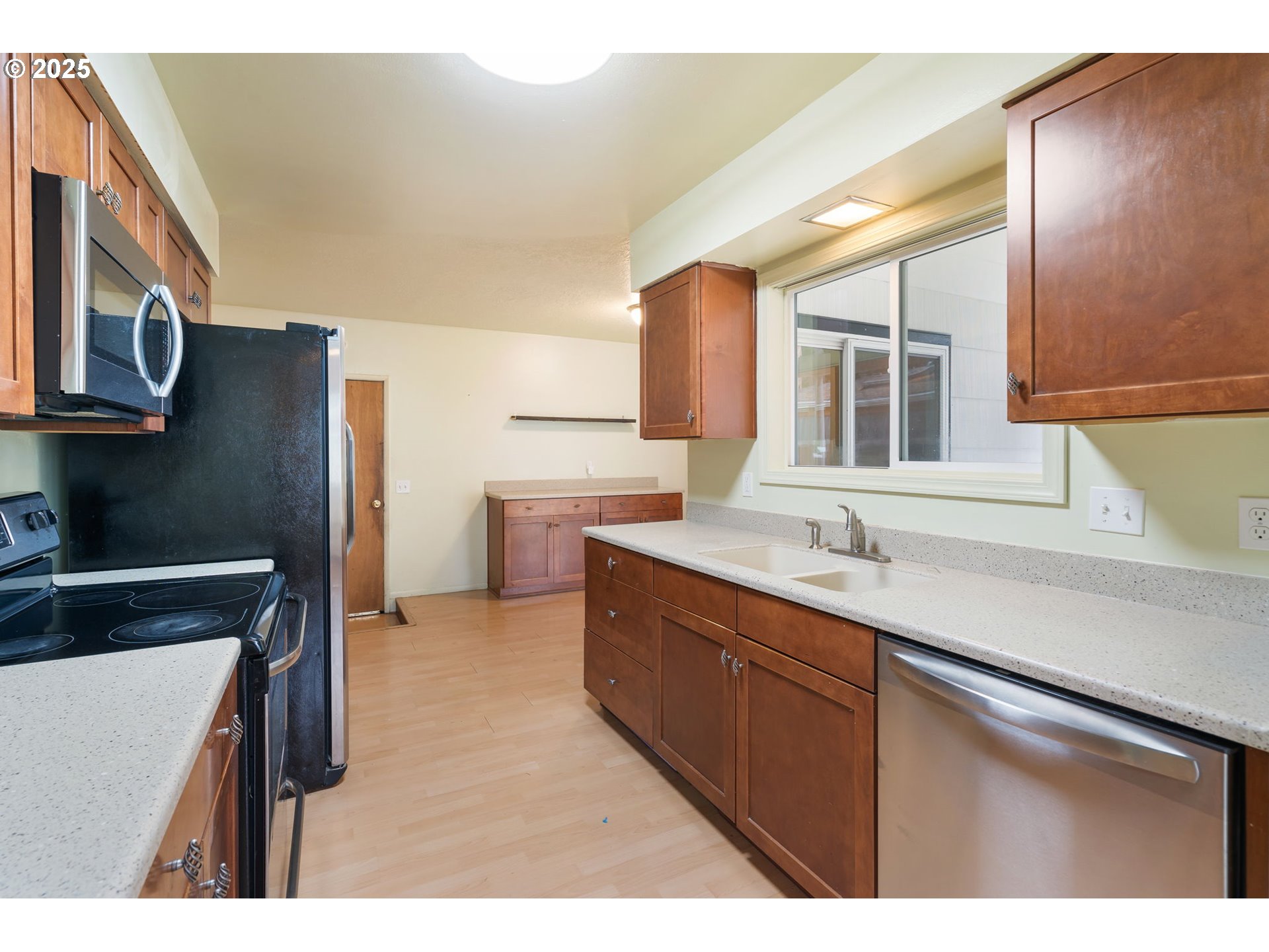 11010 Southeast Salmon Street Portland, OR 97216 - Photo 11 of 42 a kitchen with a sink and a refrigerator