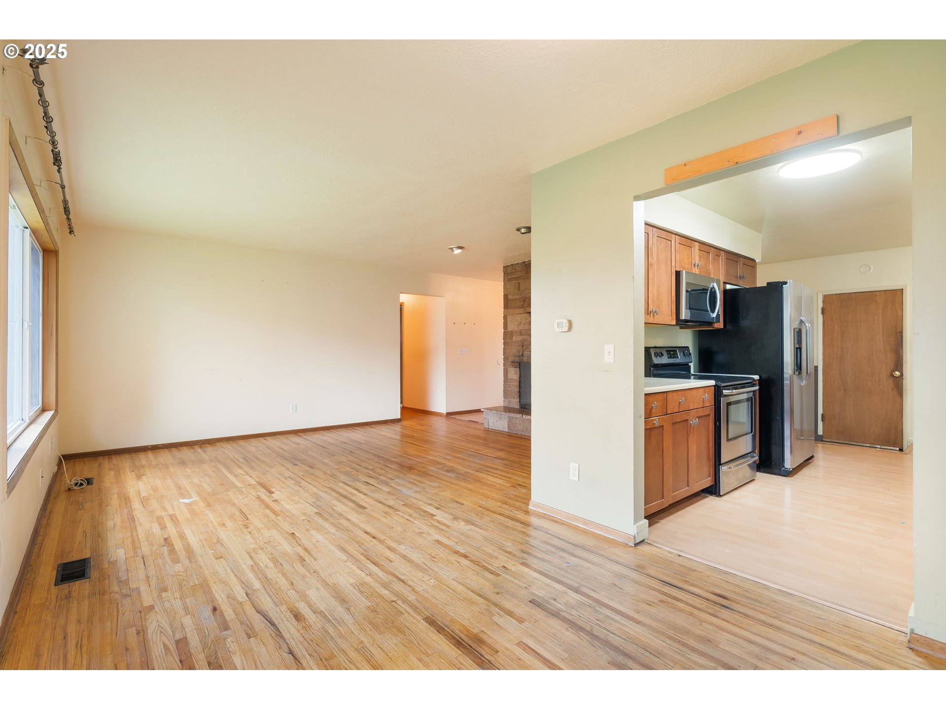 11010 Southeast Salmon Street Portland, OR 97216 - Photo 9 of 42 a view of a kitchen with wooden floor and a refrigerator