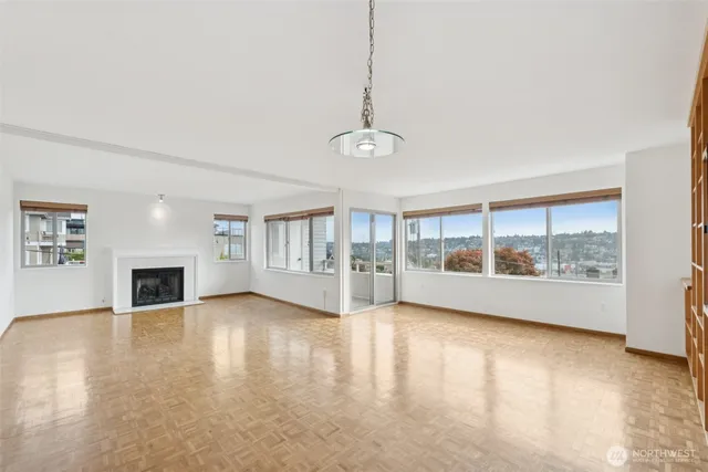 a view of empty room with wooden floor and fireplace