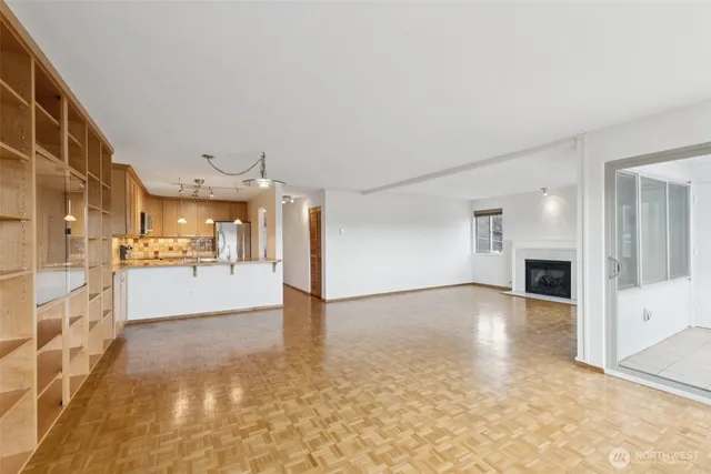 a view of a big room with wooden floor and windows