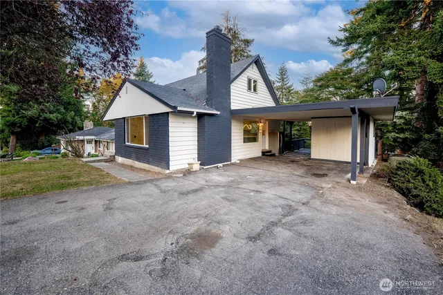 a front view of house with yard and trees all around