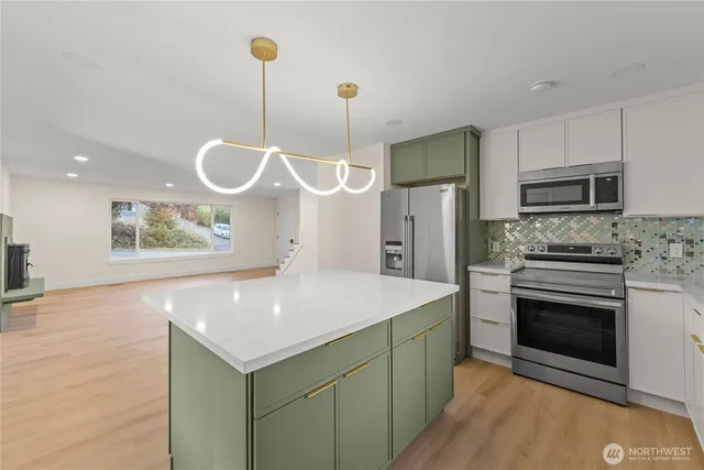 a kitchen with stainless steel appliances granite countertop a sink a stove a refrigerator and island