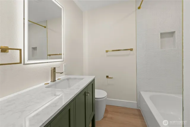 a bathroom with a granite countertop sink toilet and shower