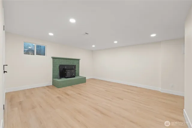 an empty room with wooden floor and fireplace