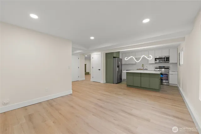 a view of a kitchen with refrigerator and a sink