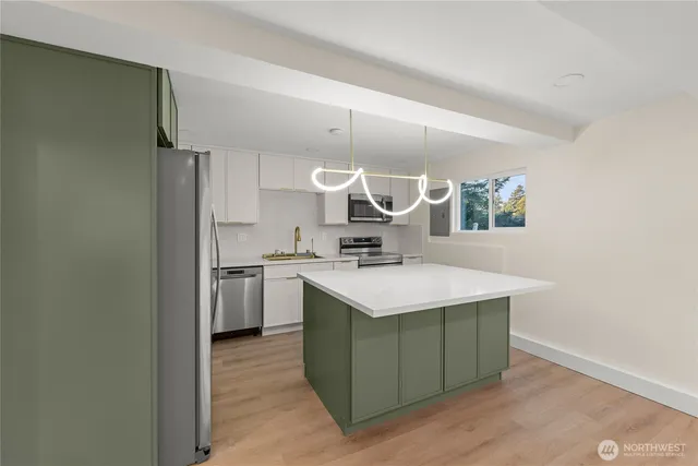 a kitchen with a sink cabinets and wooden floor