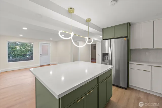 a kitchen with a refrigerator a oven a sink and a window