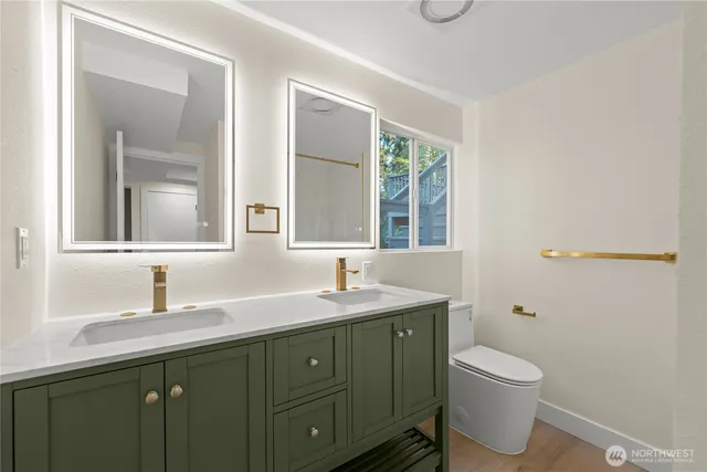 a bathroom with a granite countertop toilet sink and mirror