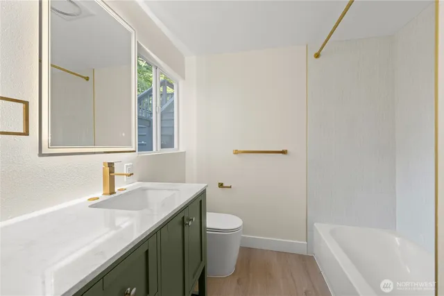 a bathroom with a granite countertop sink toilet and shower