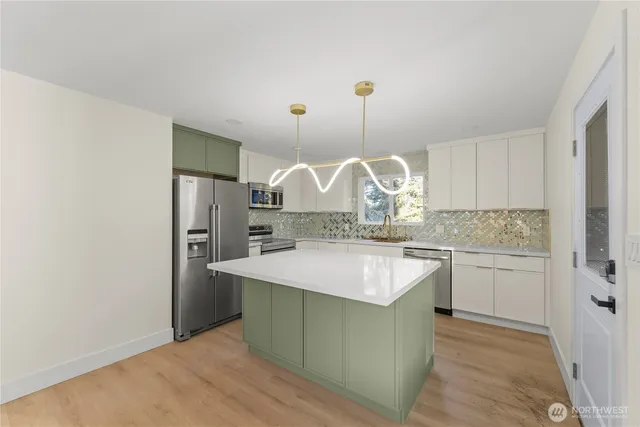 a kitchen with a sink a refrigerator and cabinets