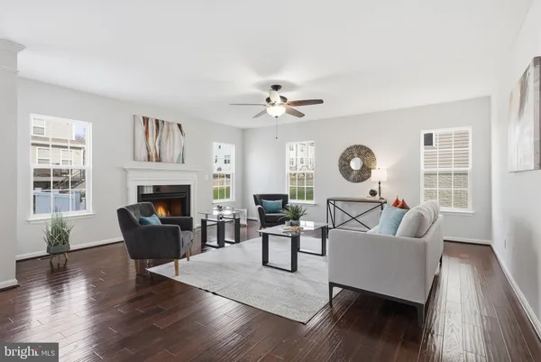 a living room with furniture a fireplace and wooden floor