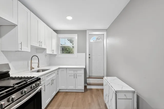 a kitchen with a sink stove top oven and cabinets