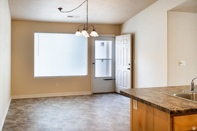 1330 North Dixie Downs Road, Unit 72 St. George, UT 84770 - Photo 5 of 21 Kitchen featuring dark countertops, suspended lighting, and stone finish floors