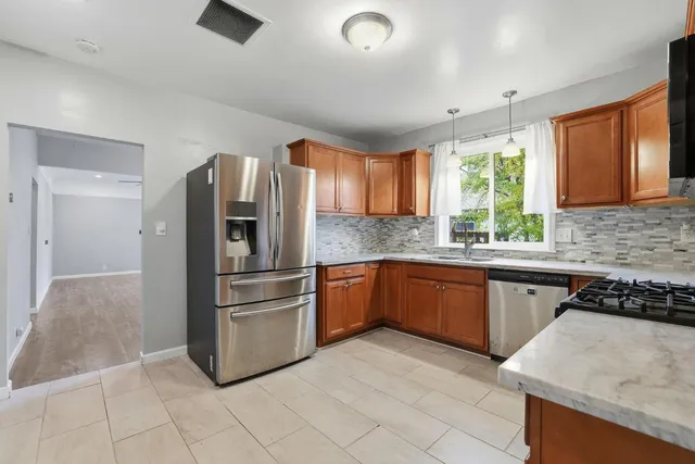 a kitchen with granite countertop a refrigerator and a sink