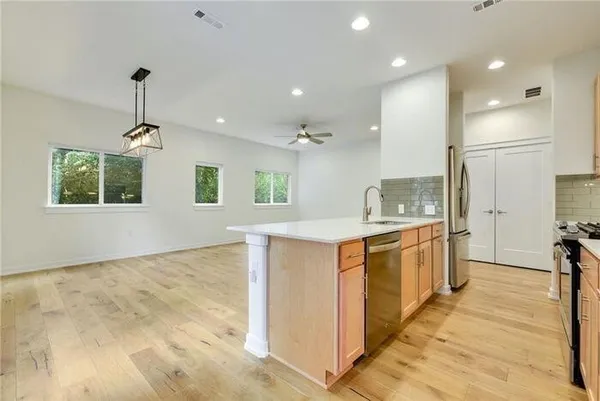 a large kitchen with kitchen island a sink stainless steel appliances and cabinets