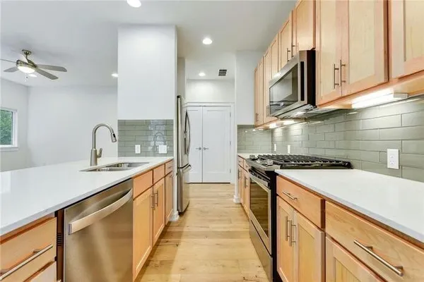 a kitchen with stainless steel appliances granite countertop a sink stove and cabinets