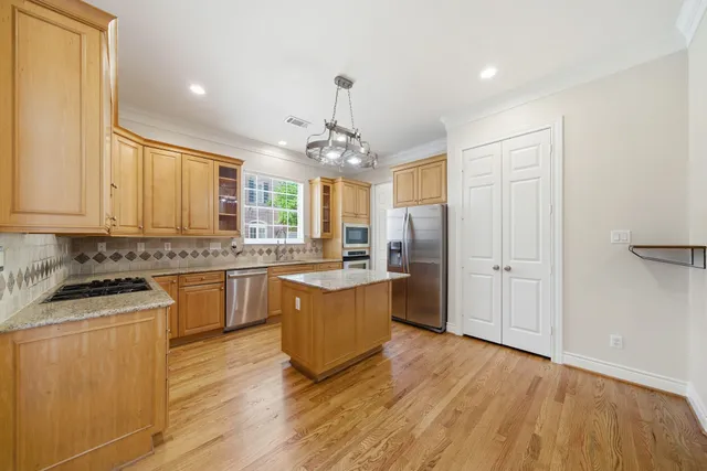 a kitchen with granite countertop a sink cabinets and wooden floor