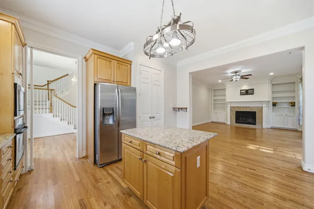 a kitchen with stainless steel appliances granite countertop a refrigerator a oven and a wooden floors