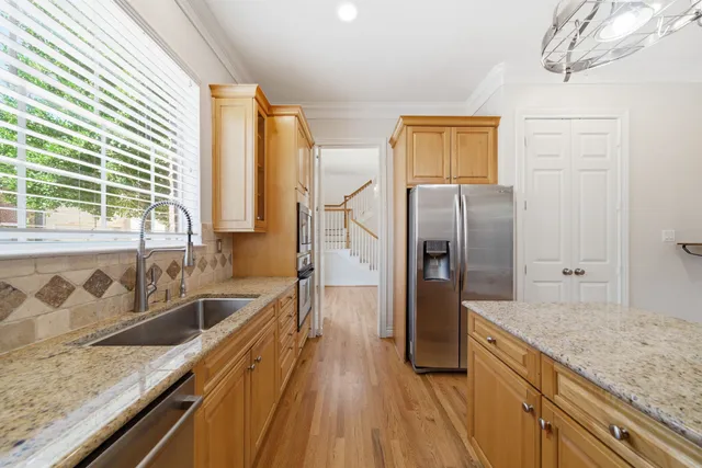 a kitchen with granite countertop a refrigerator and a sink