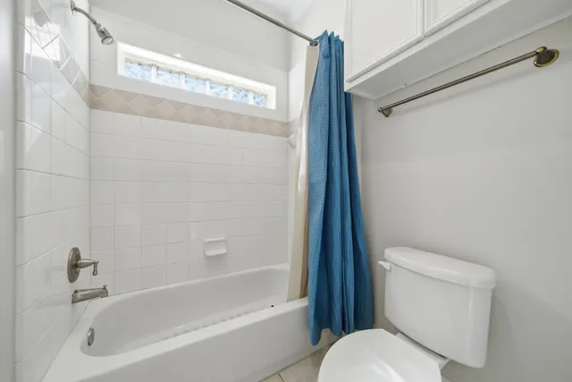 a white toilet sitting next to a bath tub