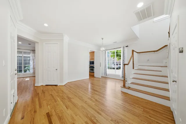 a view of empty room with wooden floor and window