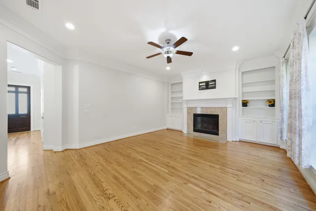 a view of empty room with wooden floor and fireplace