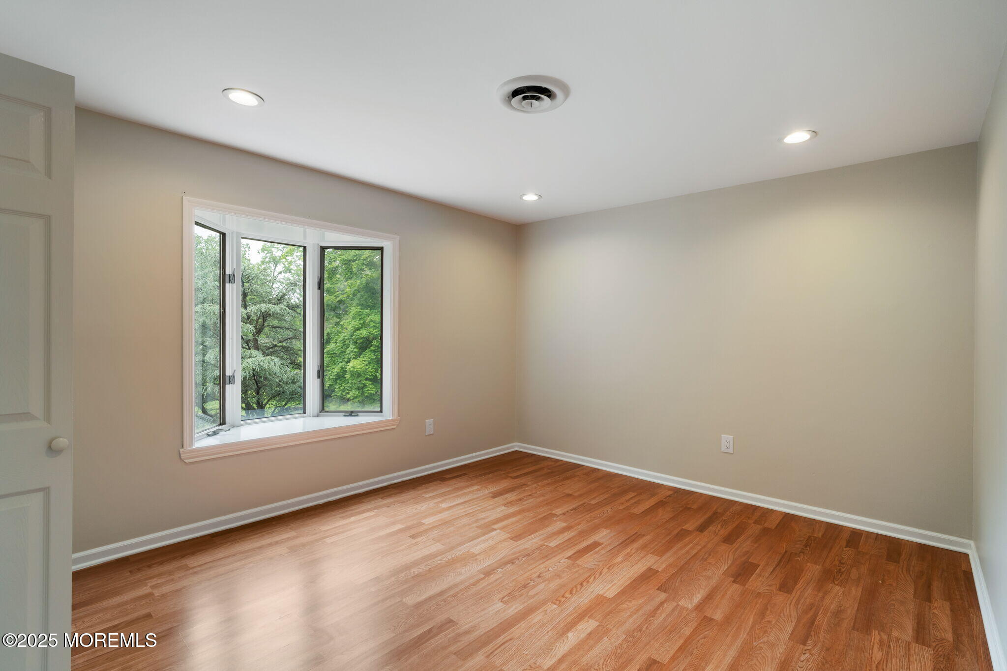 245 Borden Road Middletown, NJ 07748 - Photo 44 of 72 an empty room with wooden floor and windows