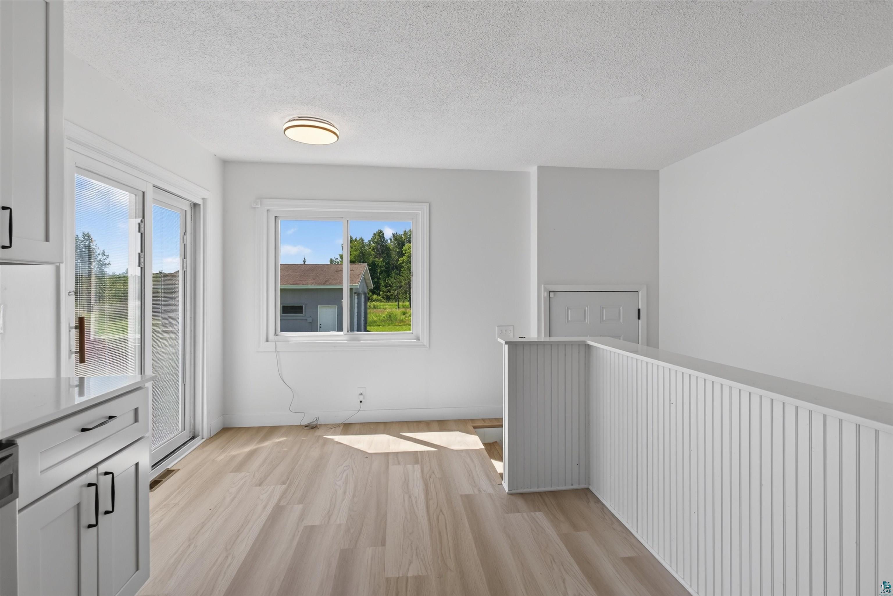 5868 Rice Lake Road Duluth, MN 55803 - Photo 16 of 39 Light wood-finish flooring complements the bright white walls and trim