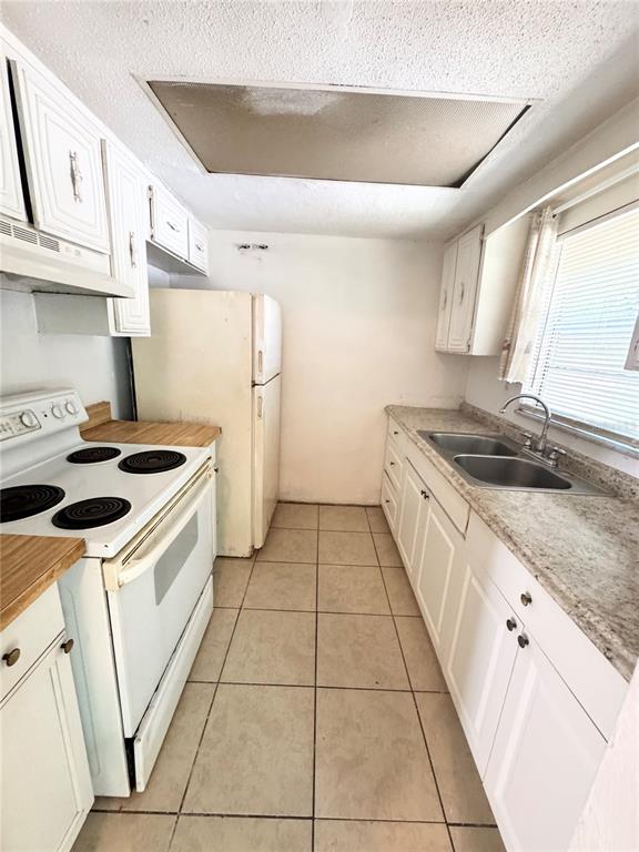 1229 Kennedy Road, Unit 43 Daytona Beach, FL 32117 - Photo 5 of 9 a kitchen with a sink a stove oven and white cabinets