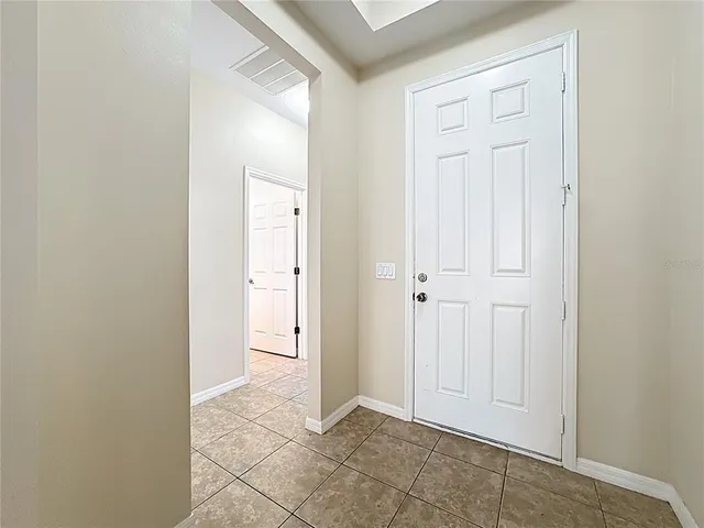 an empty room with kitchen view