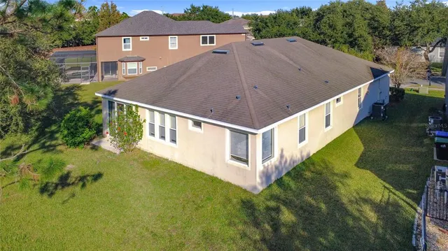 an aerial view of residential houses with outdoor space and trees