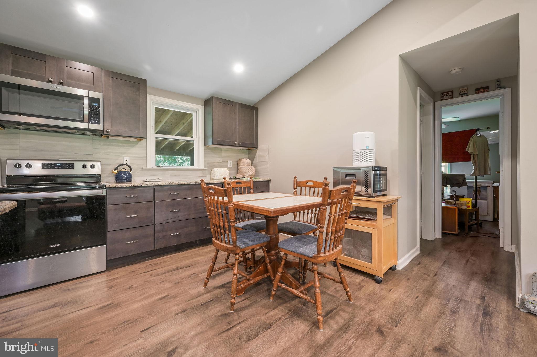 2821 Sandtown Road Felton, DE 19943 - Photo 13 of 26 a kitchen with stainless steel appliances wooden floors and wooden cabinets