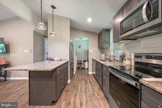 a kitchen with stainless steel appliances granite countertop counter space a sink and cabinets
